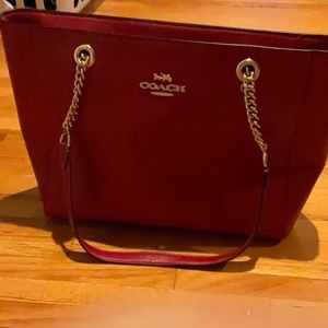 Coach red handbag with gold accents.